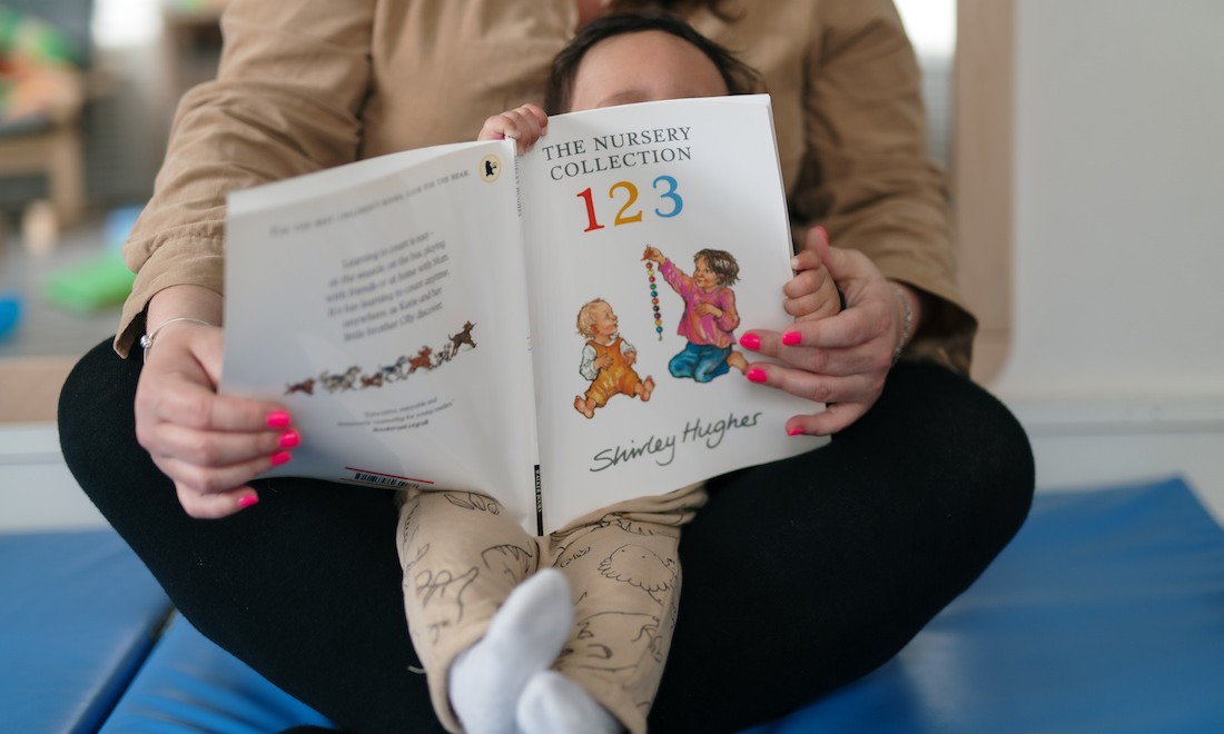 Preschool assistant reading with child