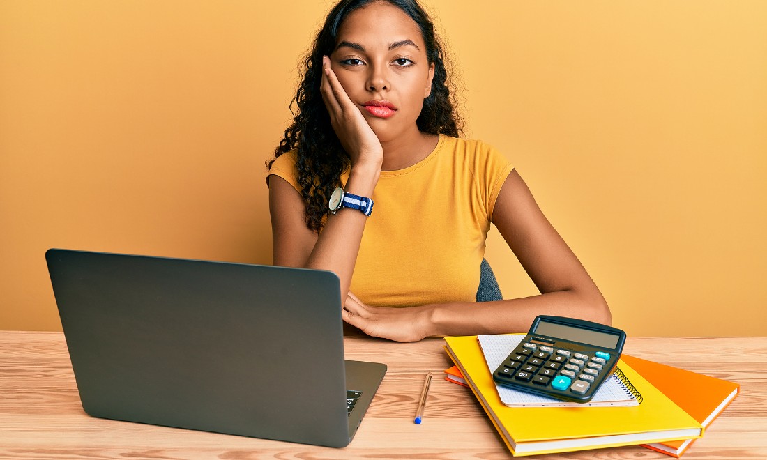 woman behind laptop, looking very bored