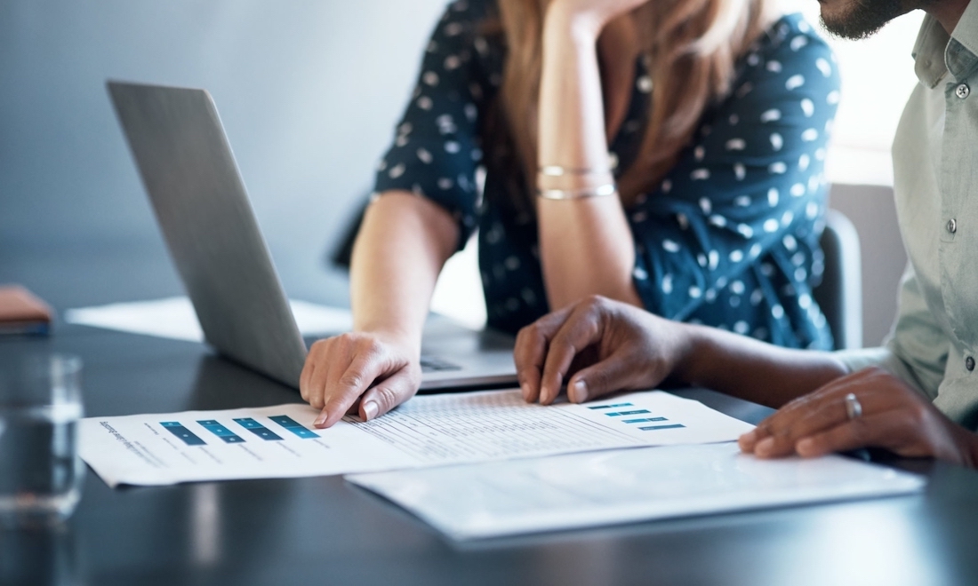 Two employees studying business plans