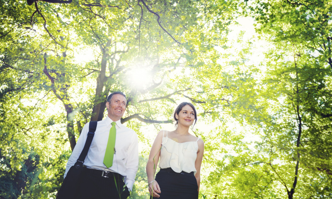 business man and woman walking in a park