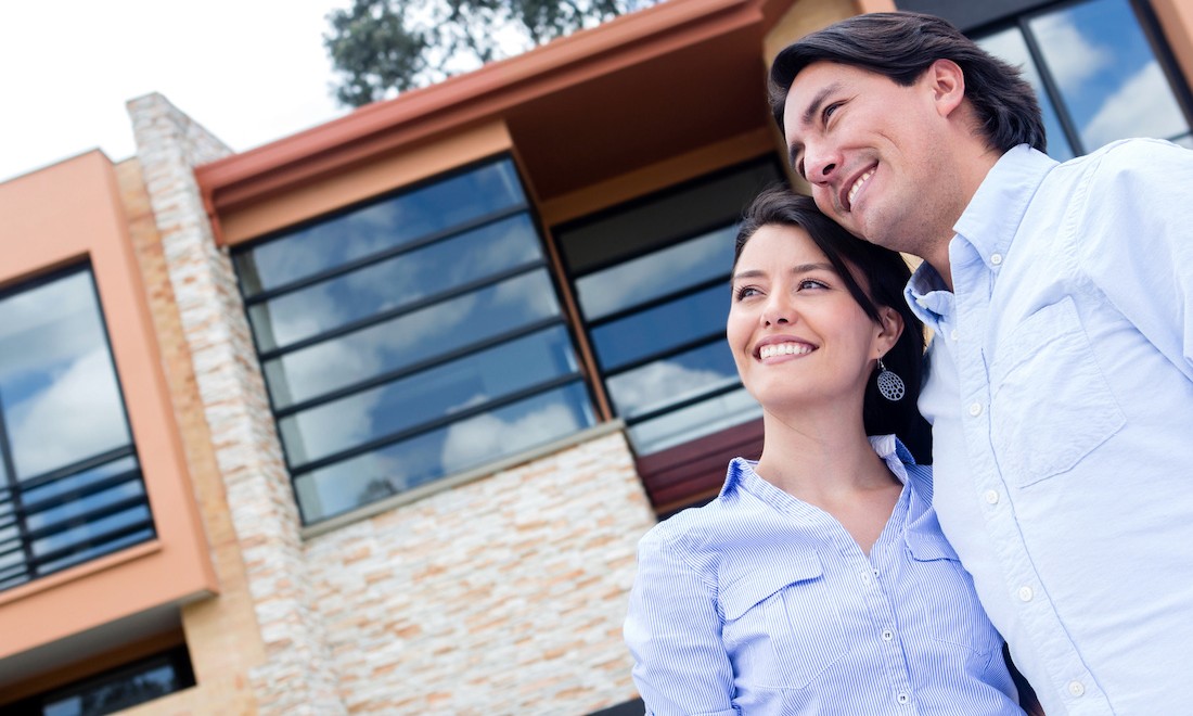 Couple standing outside new house