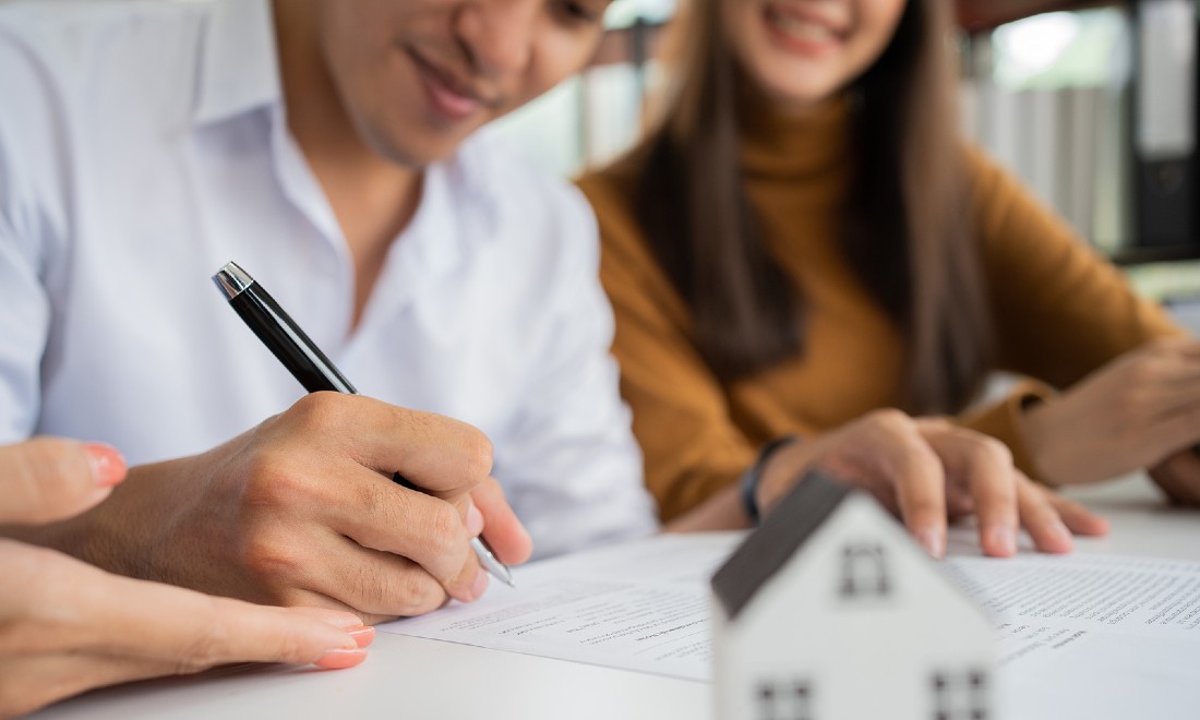 couple signing papers - buying a house in the Netherlands ABN AMRO