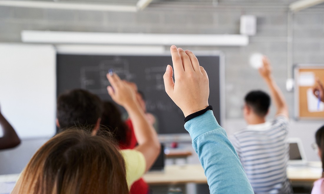 Students raising their hands in classroom