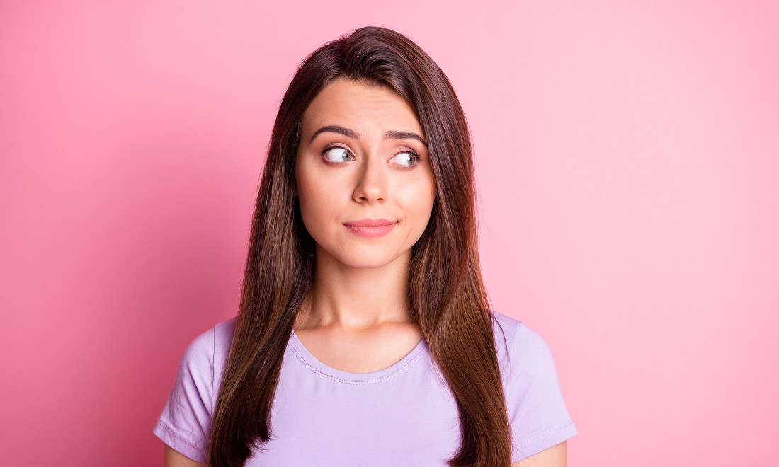 woman looking skeptical pink background