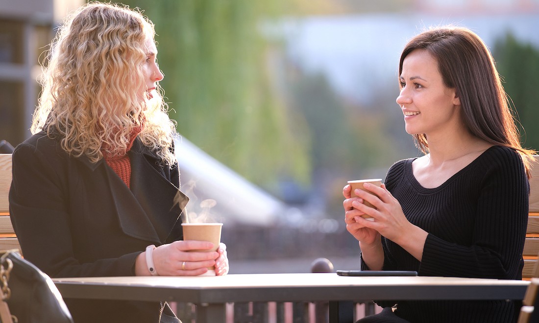 Two women talk over coffee