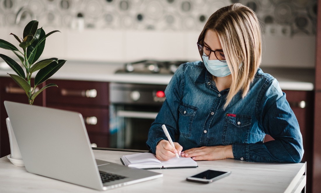 woman wearing mask coronavirus working from home laptop