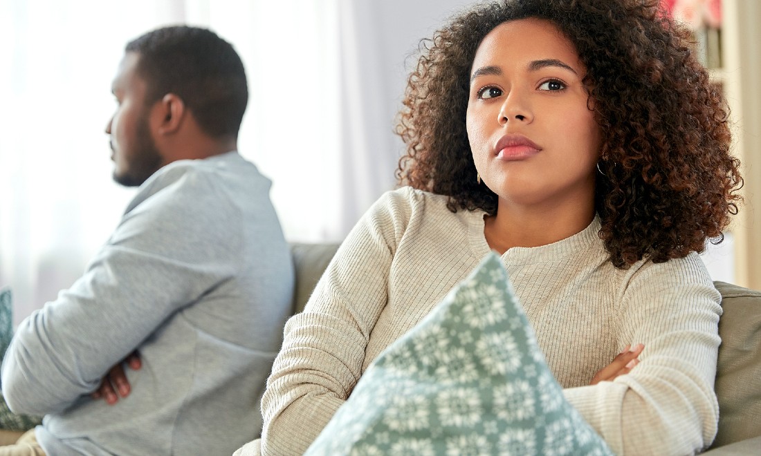 couple turned away from each other on couch, arguing