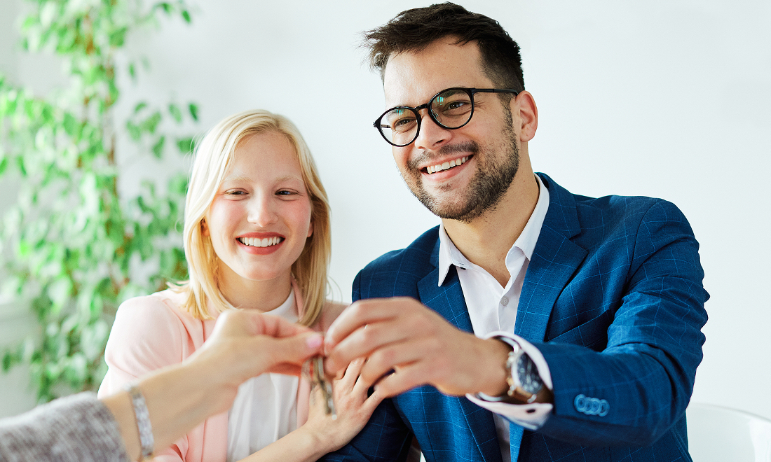 smiling-couple-receiving-keys-house