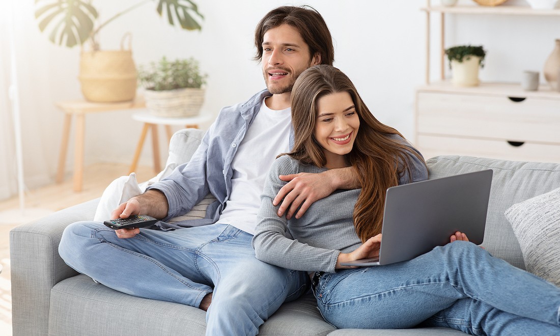 Couple watching TV and on laptop