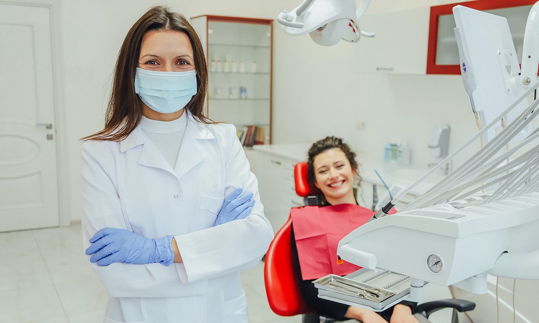 Dentist wearing safety equipment with client