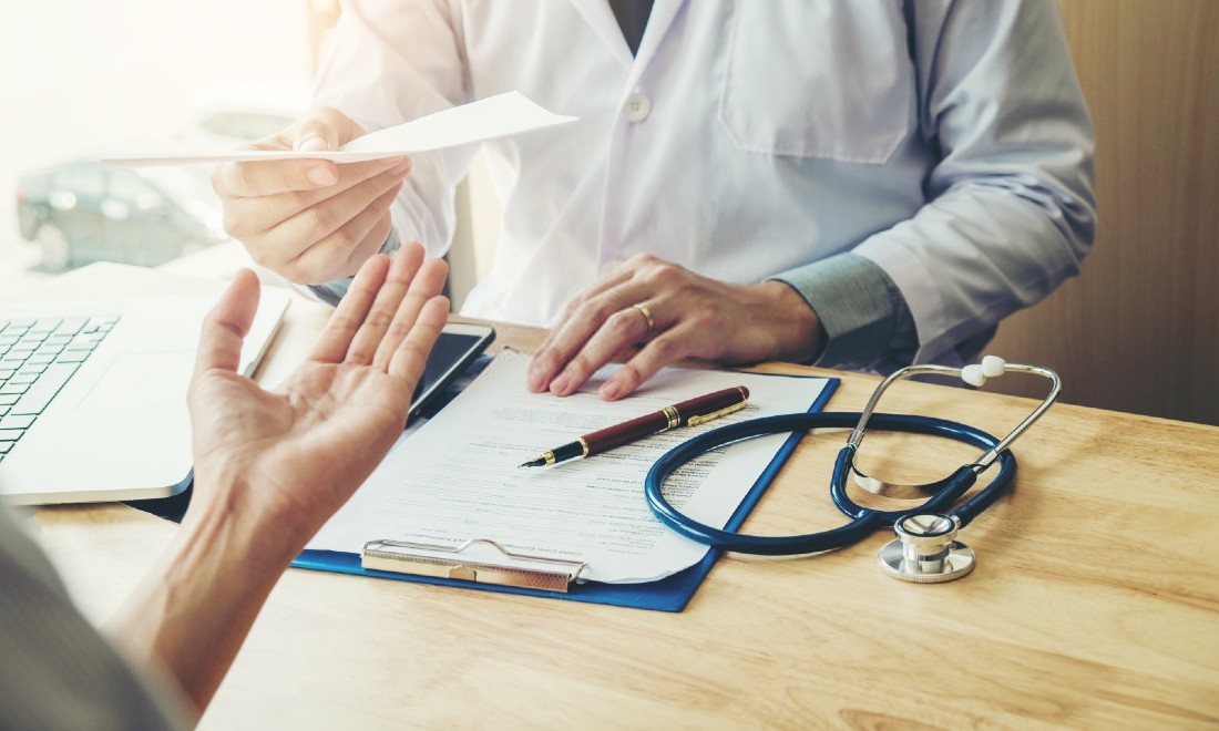 doctor handing prescription to patient