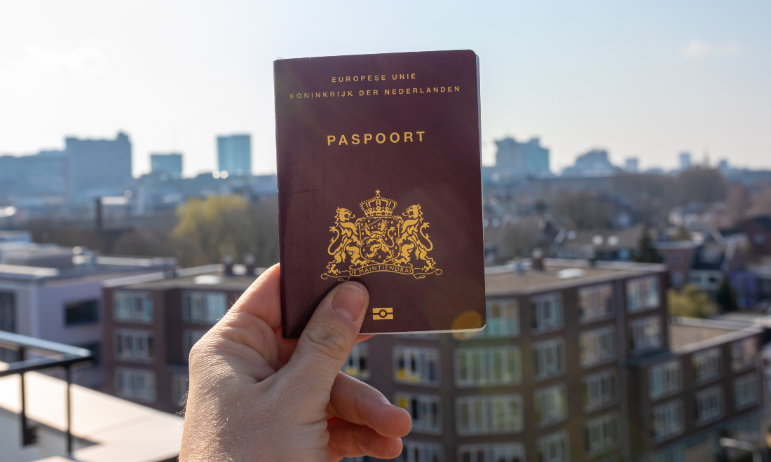 Hand holding a Dutch passport