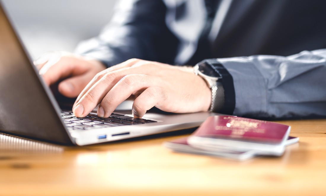 man on laptop with passport