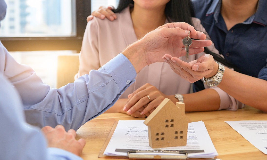 couple at real estate agent getting keys to new house