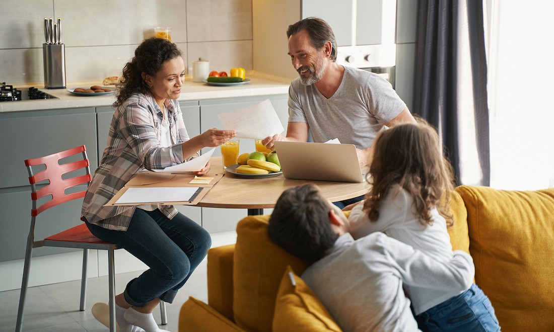 Parents doing taxes with children looking