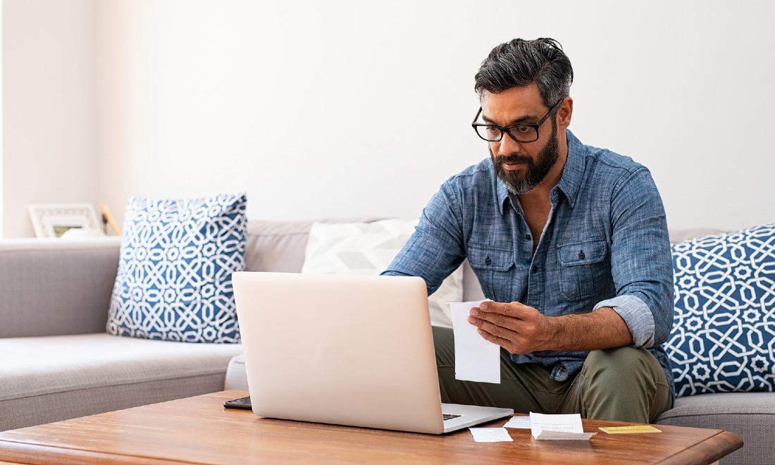 man doing taxes on laptop