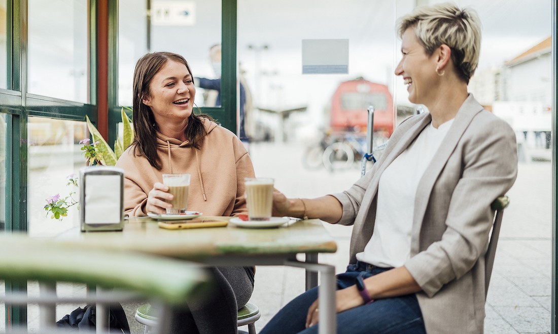 Two friends laughing over coffee