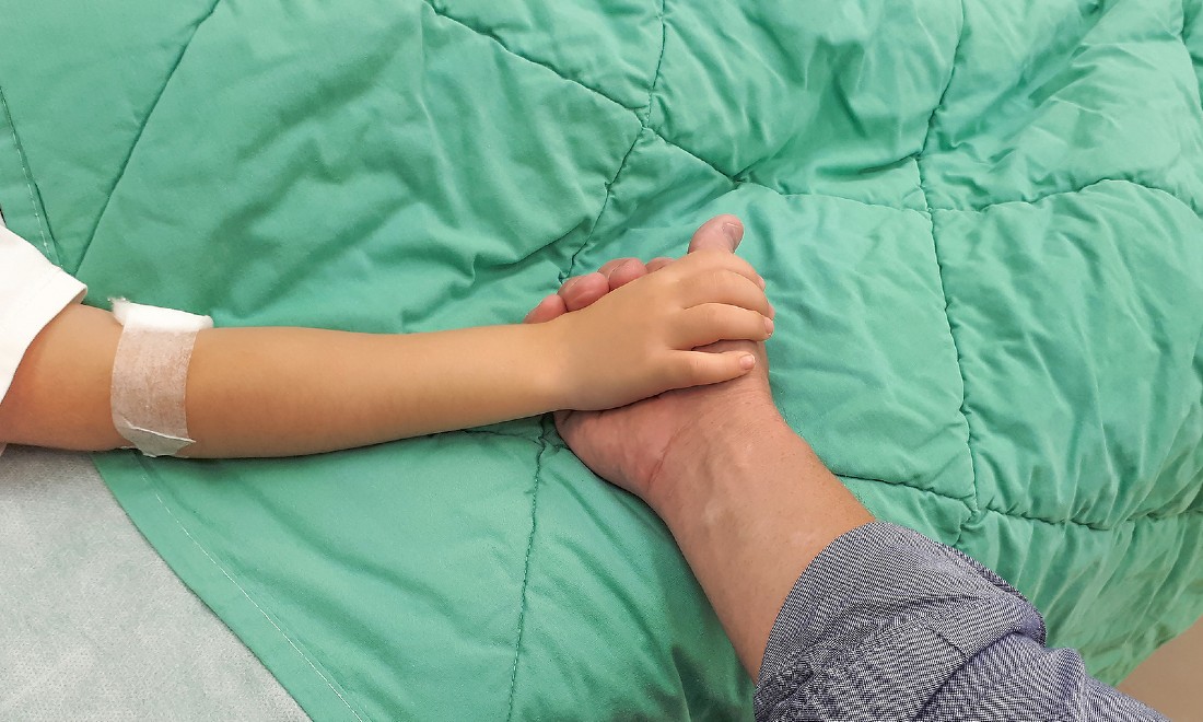 hands of child and parent in hospital