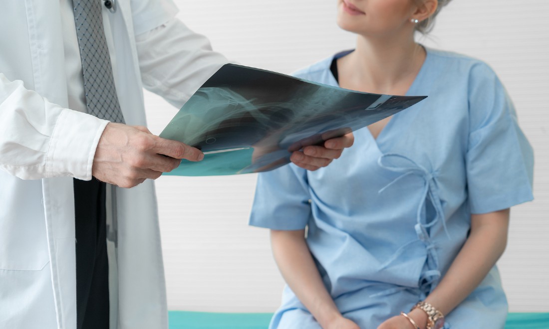 woman at doctor who is holding xray