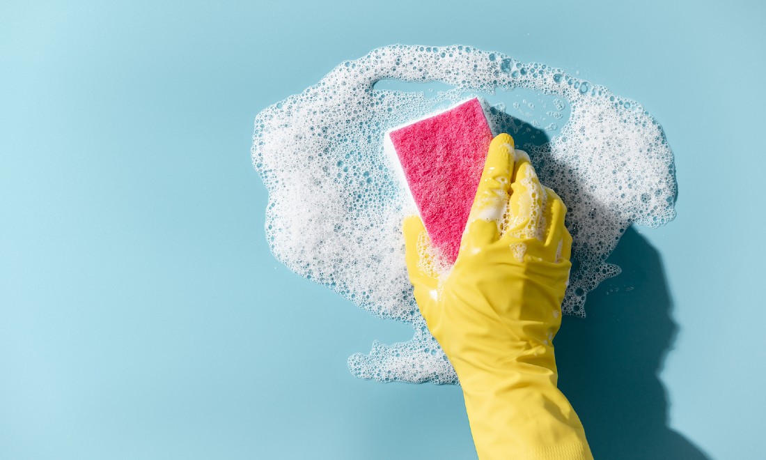 close up of gloved hand with sponge cleaning