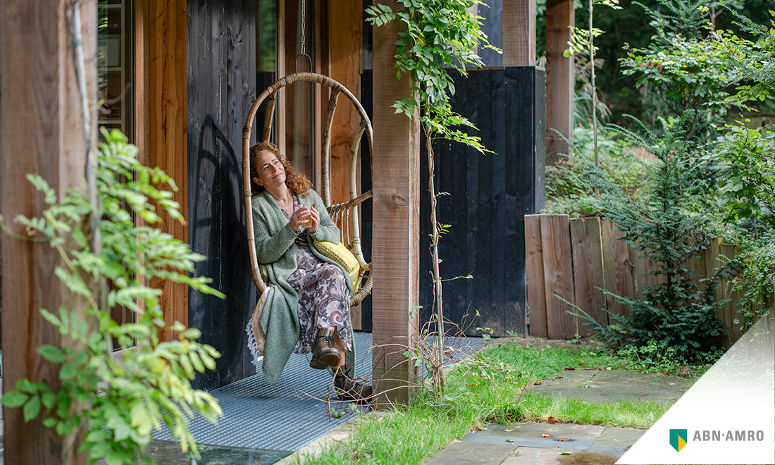 woman sitting in garden in front of home