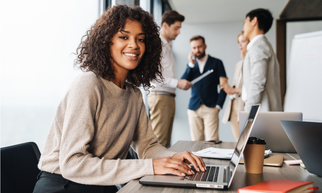 woman in office smiling at camera - inclusion in a multilingual workforce