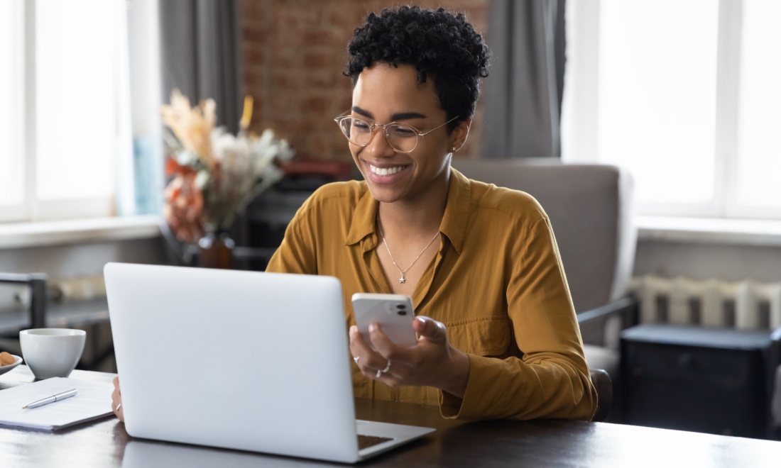 woman doing banking on laptop and phone - ING: Smart tools for instant financial insight and easy money management