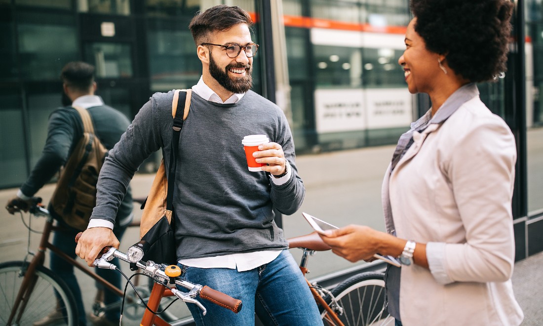 woman talking to man leaning against bicycle