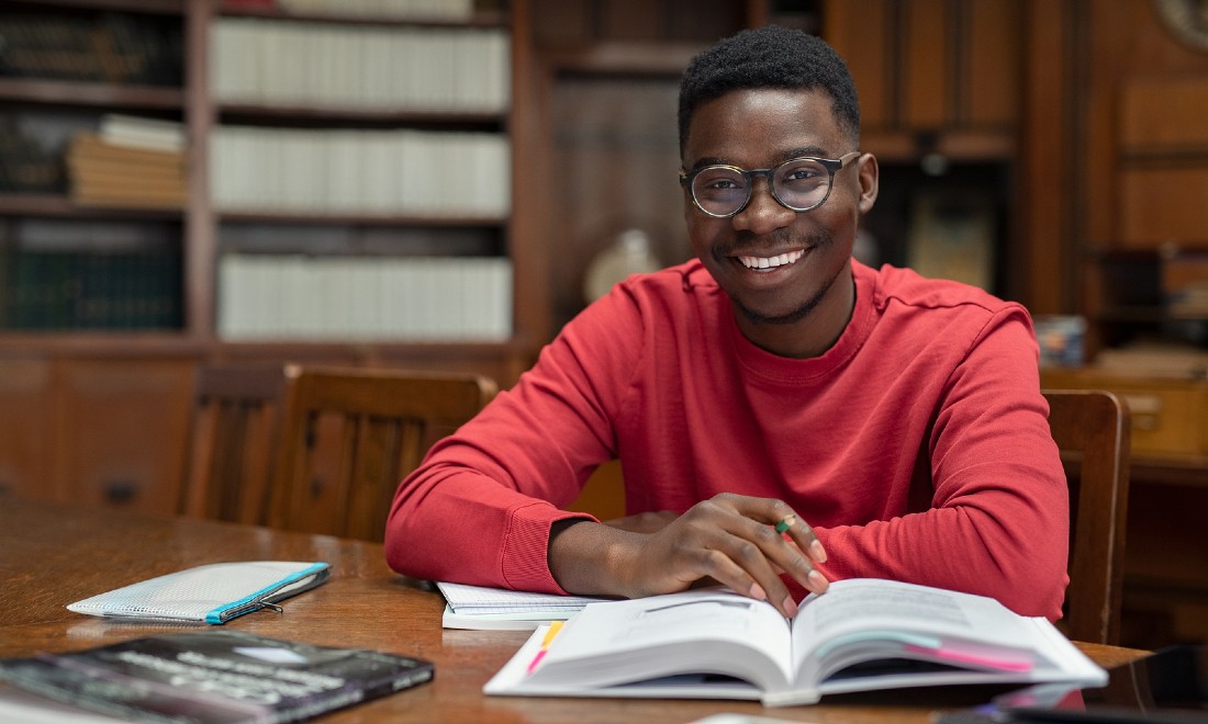 university student in library looking at camera smiling