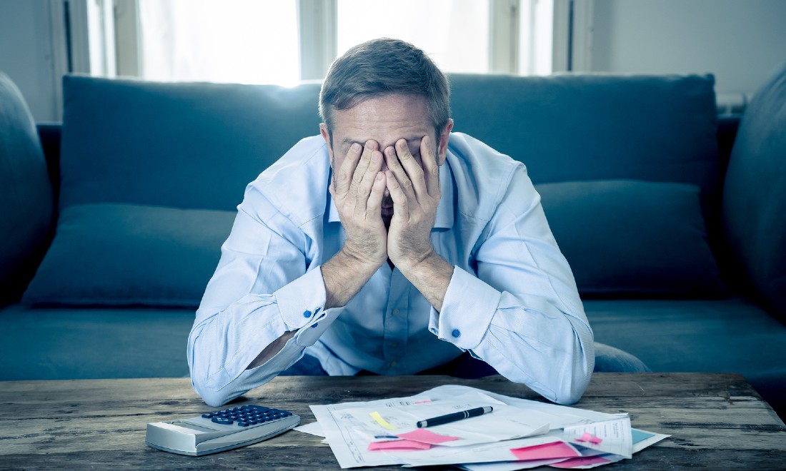 man at home calculating debt bills