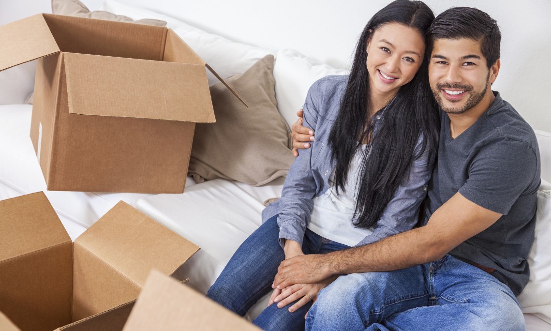 couple surrounded by moving boxes, development housing market Mie-Lan Kok