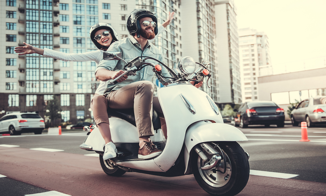 Couple on moped wearing helmets