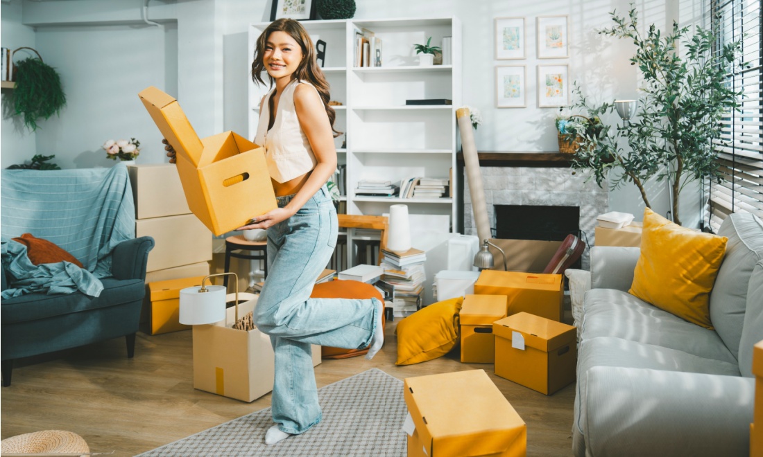 Happy woman moving boxes - klar finance mortgage summer update