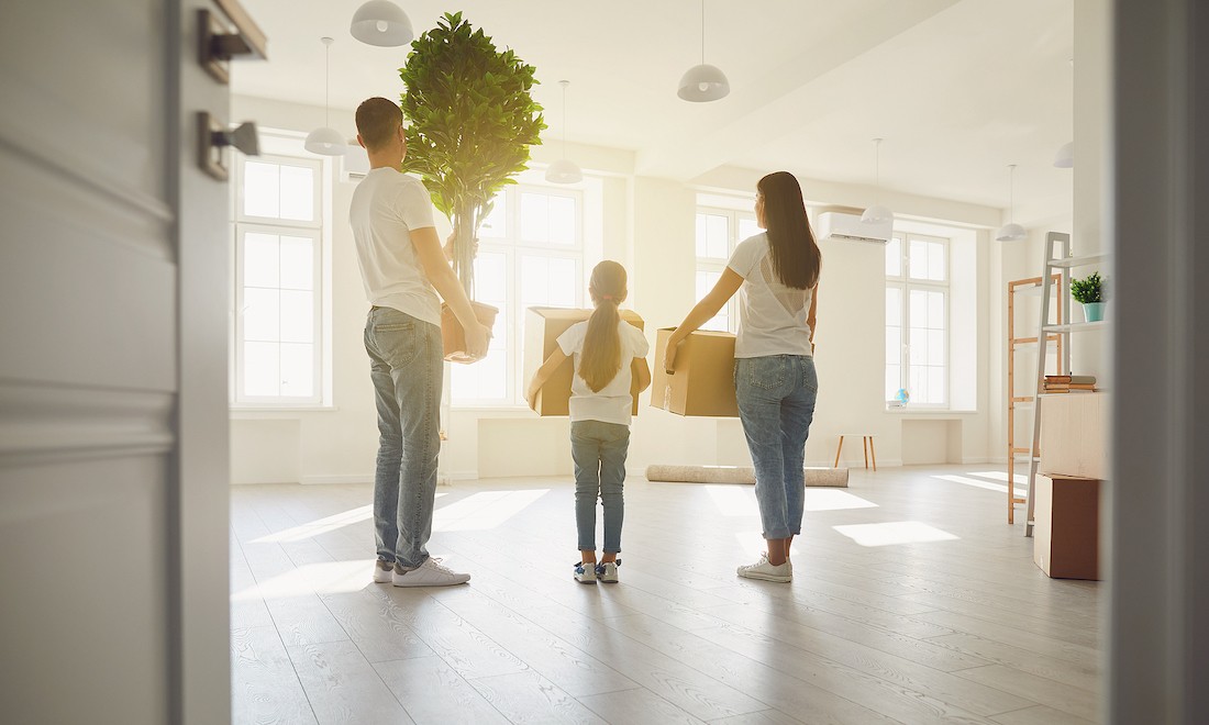 A family moving their things into a house