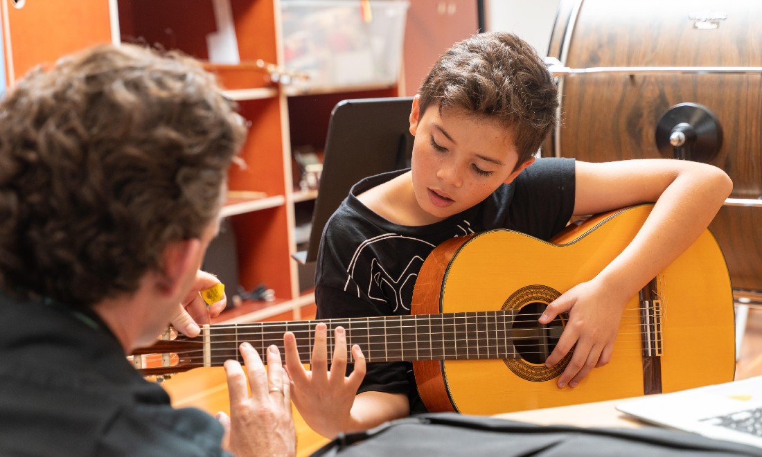 NAISR music programme - teacher and student playing guitar