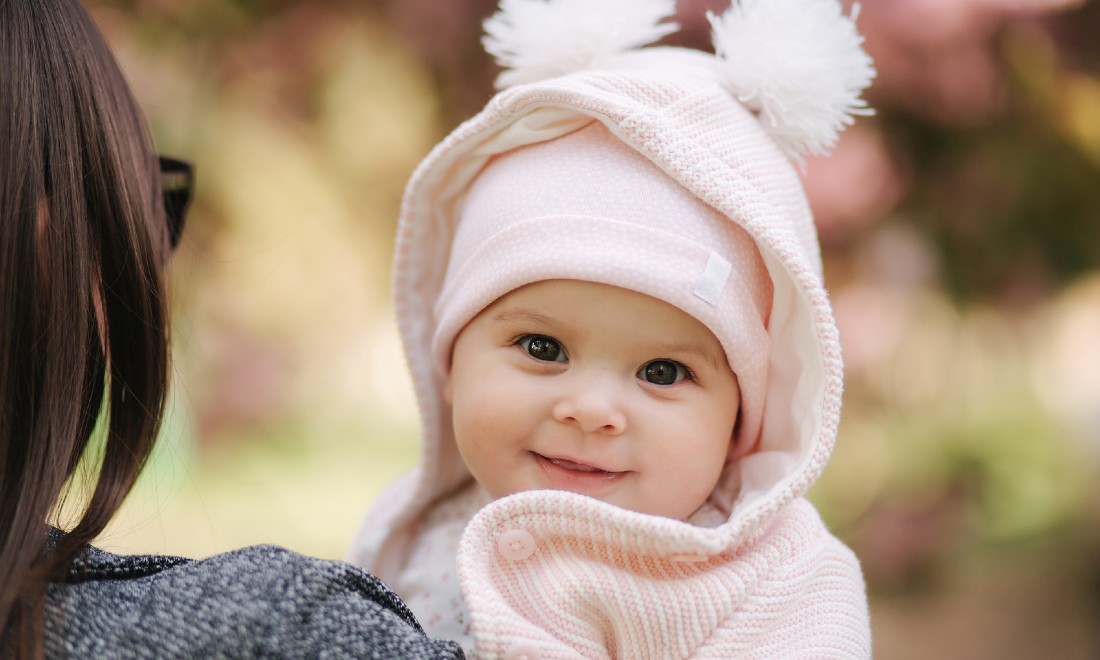 cute baby looking over shoulder woman