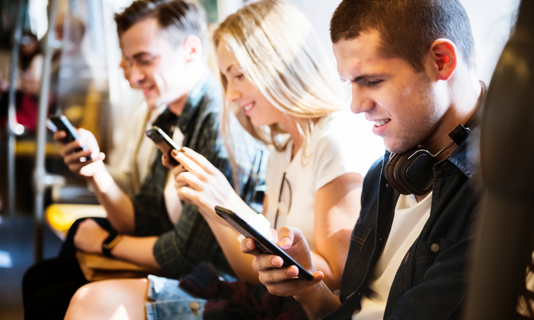 Passengers looking at phones on train