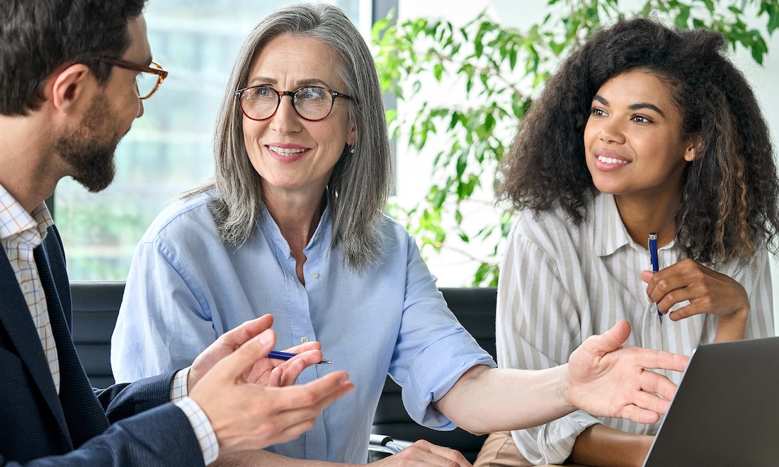 Three office workers discussing presentation