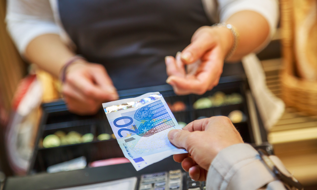 Woman paying in cash at shop till