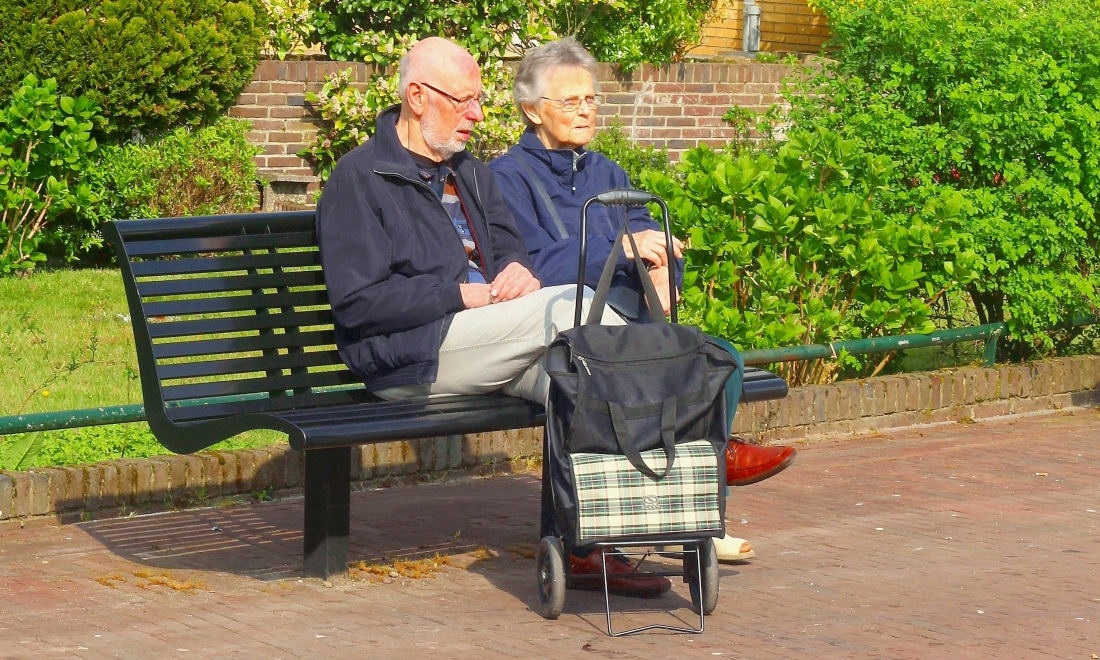 Elderly retired couple sat on a bench in the Netherlands