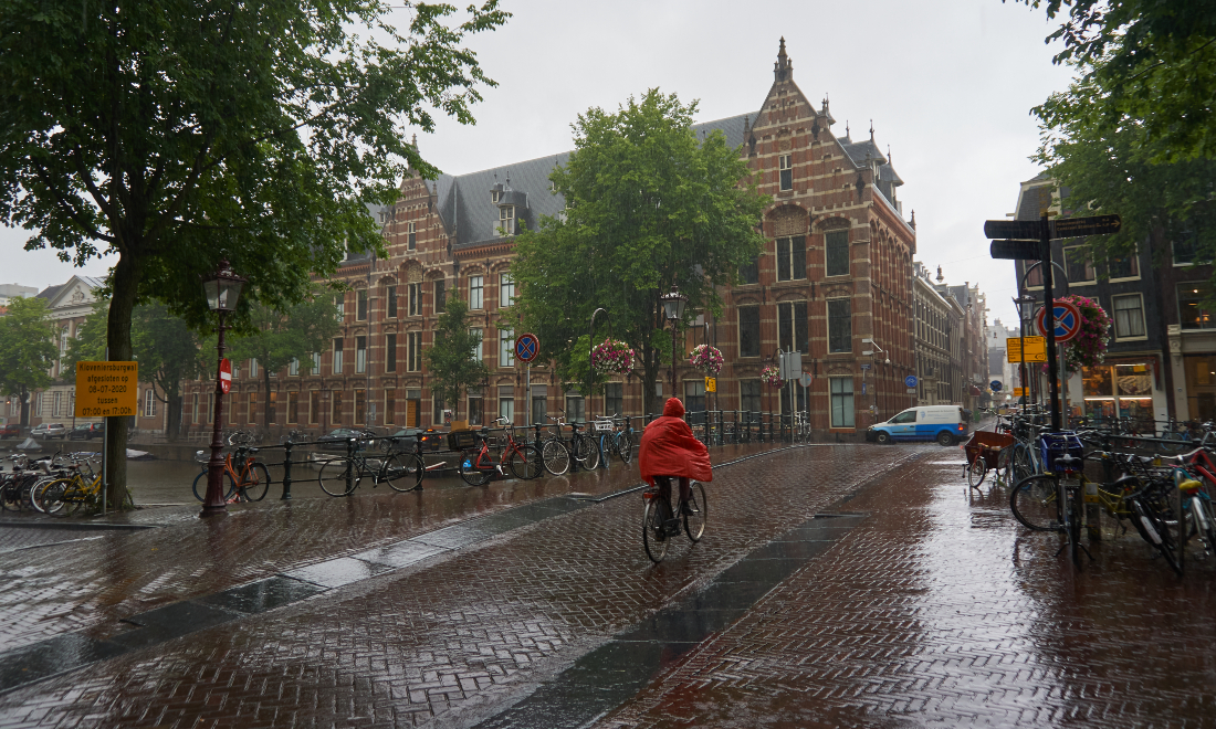 Cycling through the rain during a summer in Amsterdam