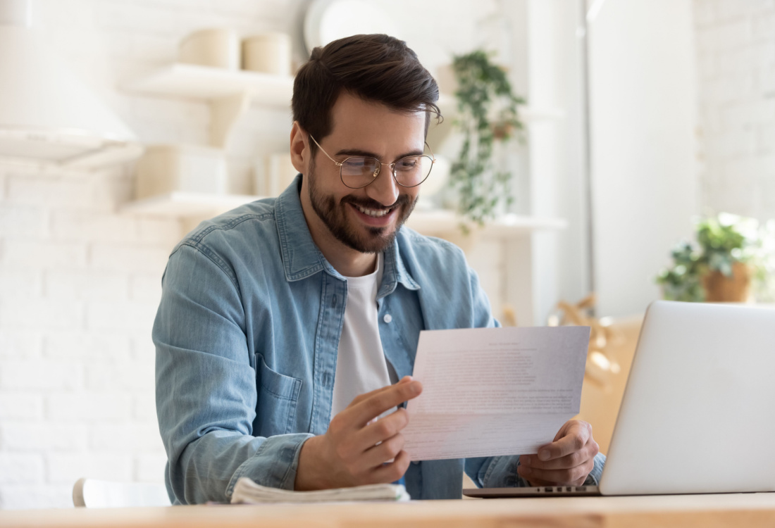 man smiling at paper 