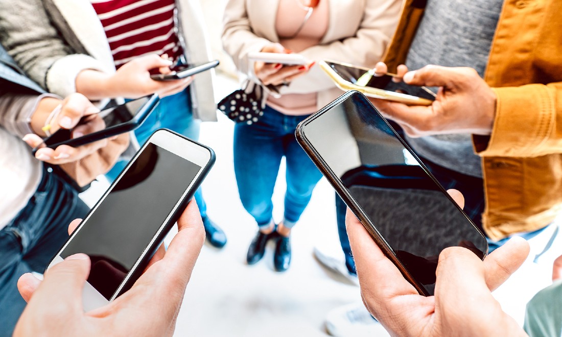 people standing in circle, holding mobile phones