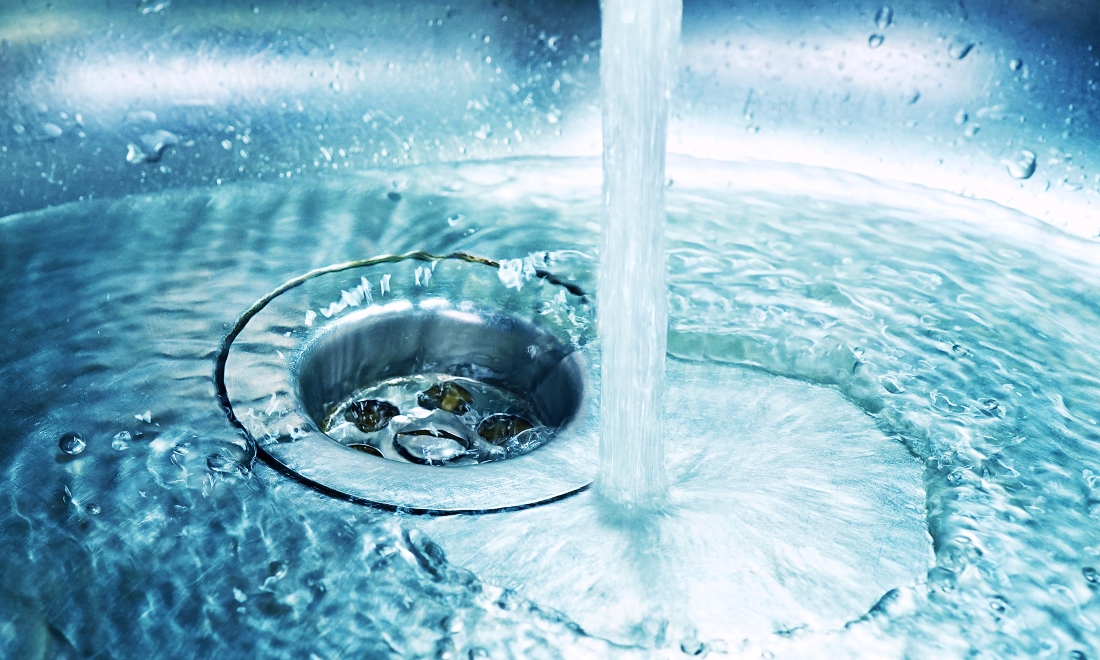 Tap running water into stainless steel kitchen sink