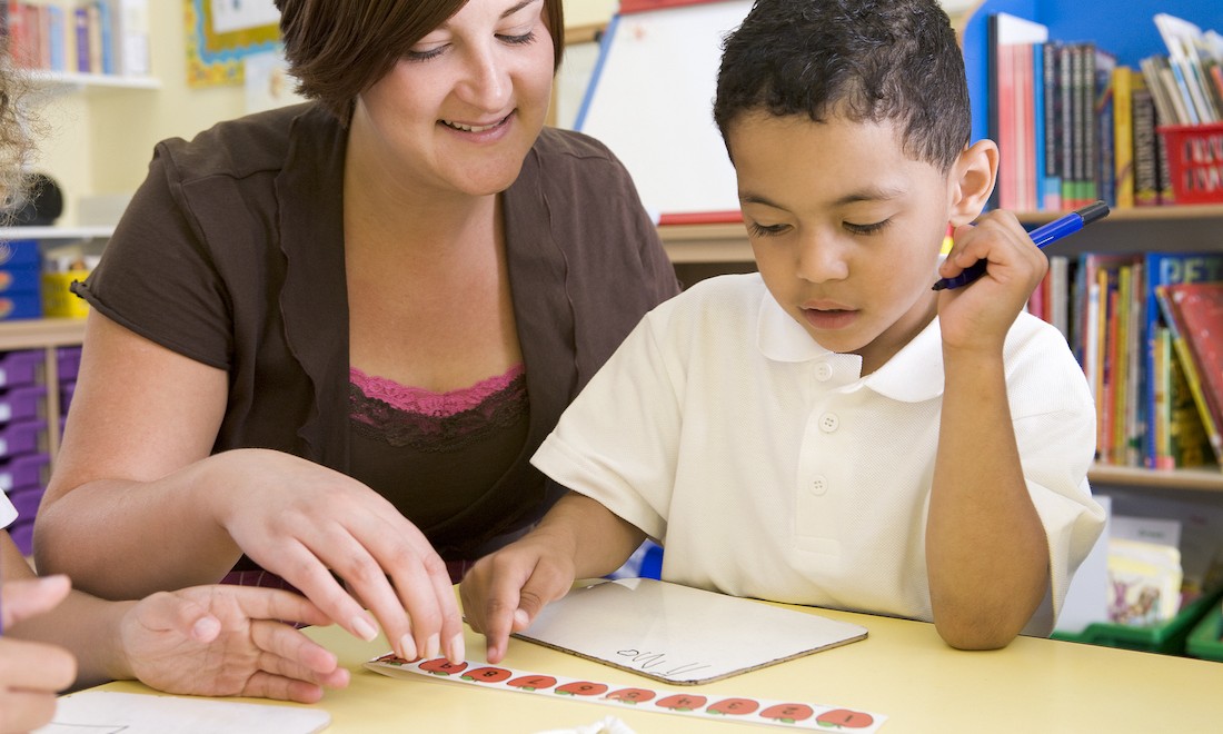 Teacher helping child in classroom