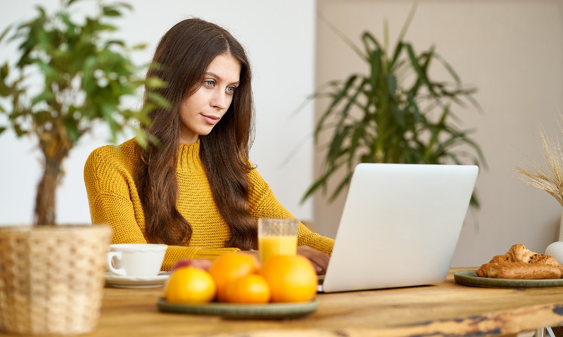 woman working from home on laptop at kitchen table