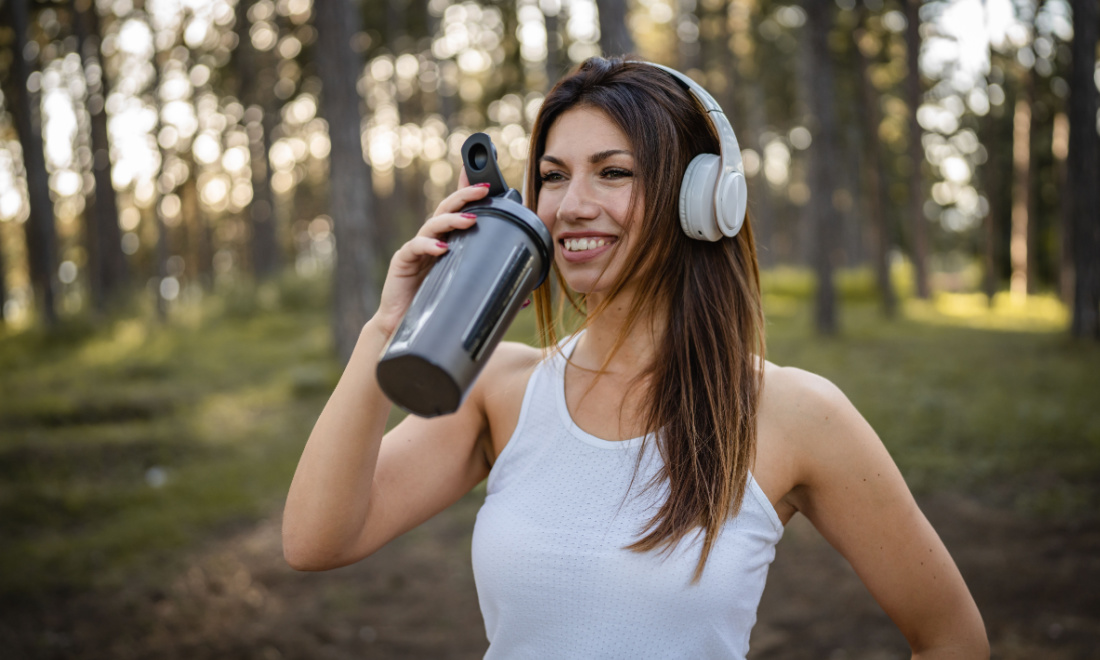 woman drinking water on a run