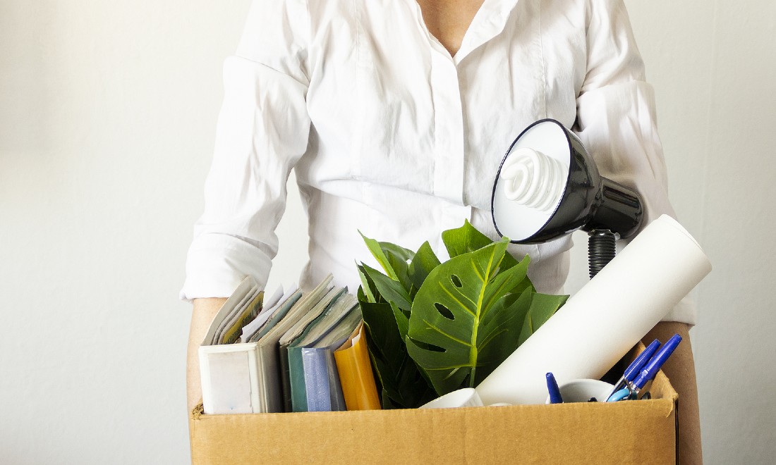 person holding box belongings office fired