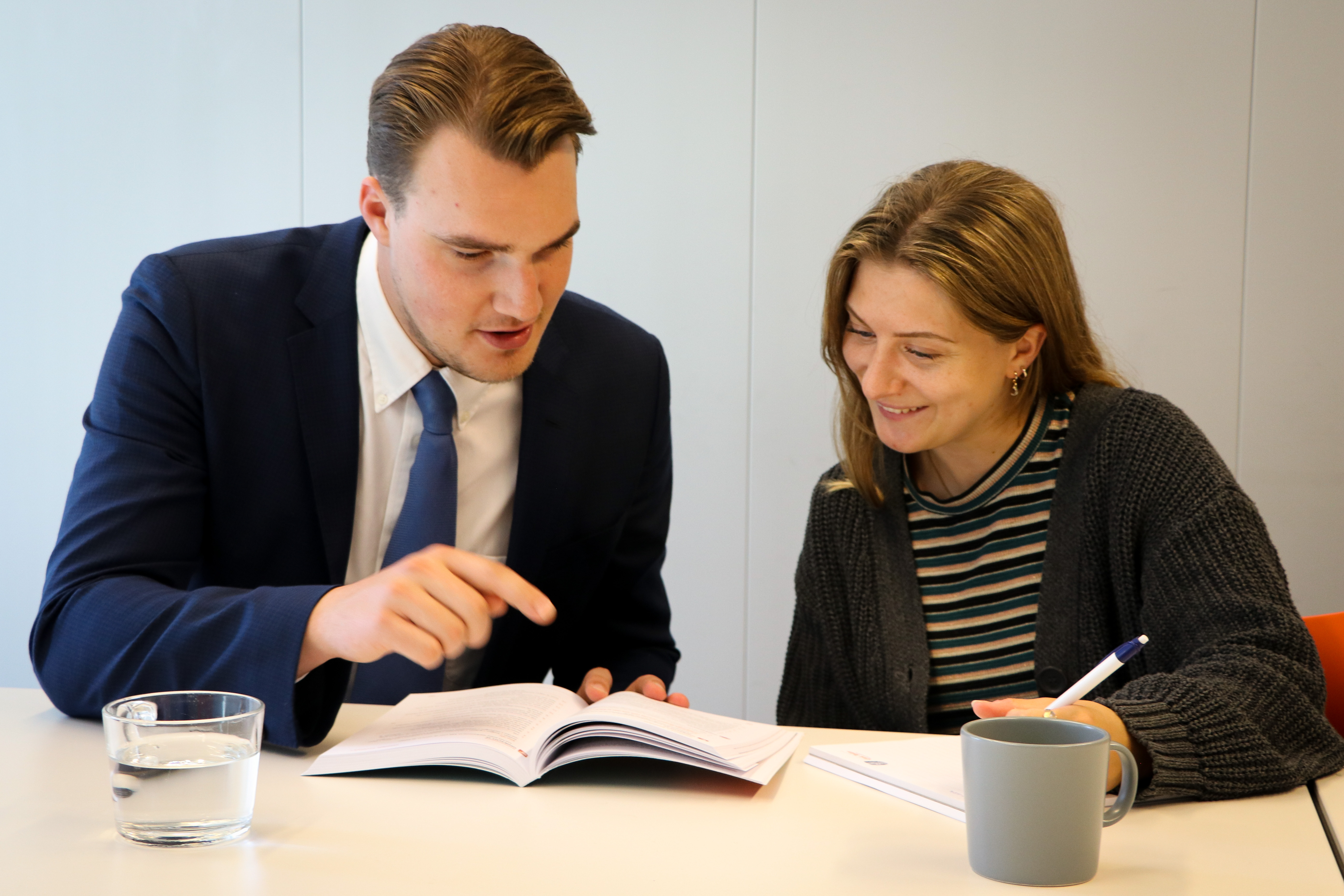 man and woman studying from book together