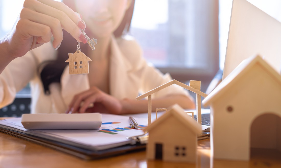 woman holding up keys to house - concept buying house